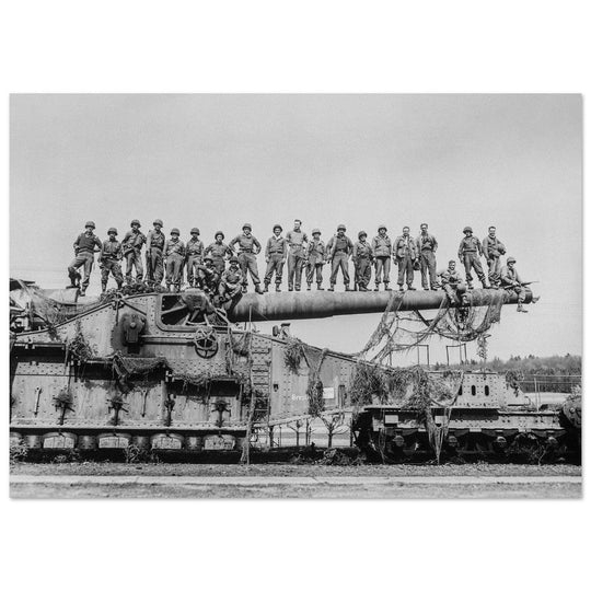 World War 2 black and white photograph. Railroad gun with soldiers on top.