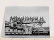 World War 2 black and white photograph. Railroad gun with soldiers on top.