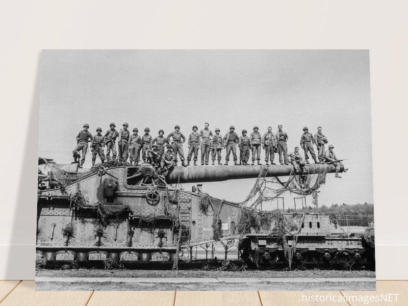 World War 2 black and white photograph. Railroad gun with soldiers on top.