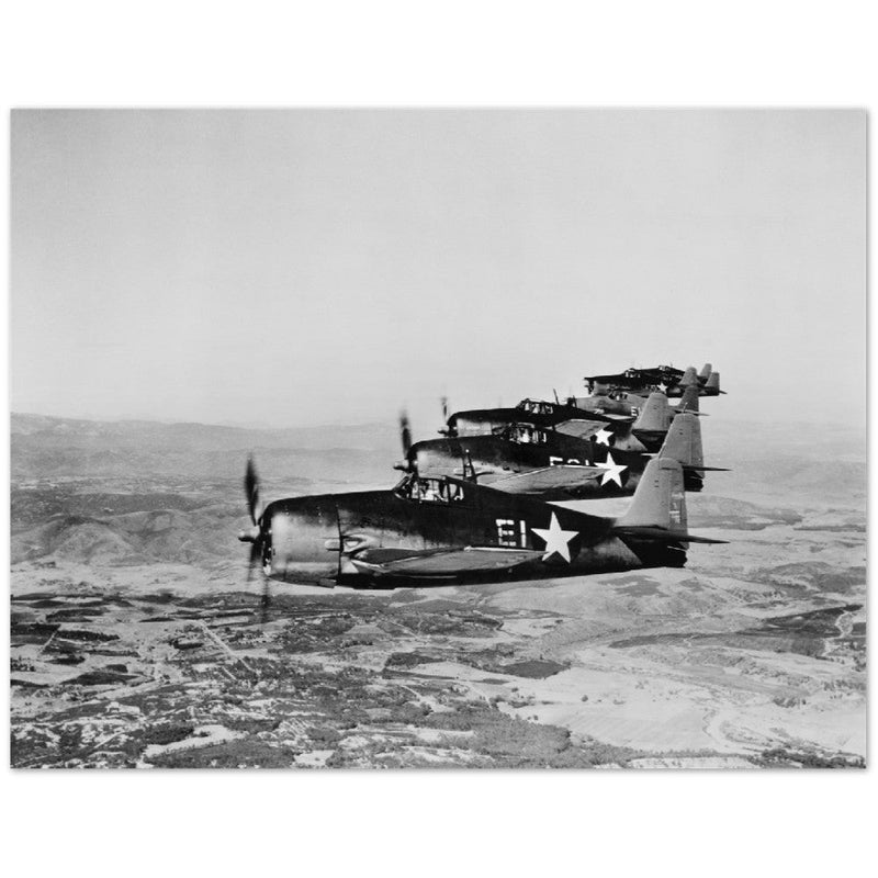 Aerial view of seven Grumman Hellcat airplanes in flight.